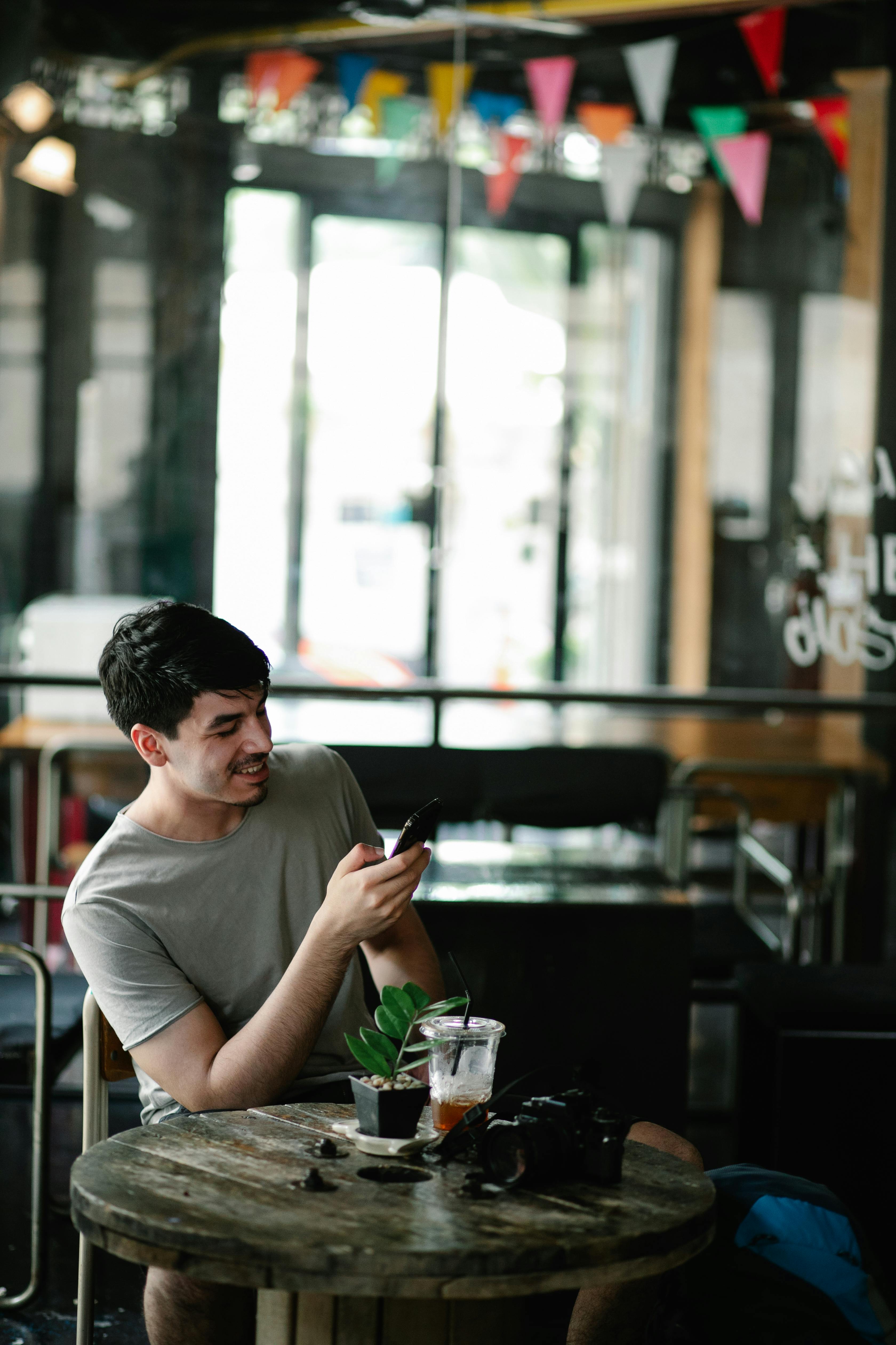 A man smiling while using his phone | Source: Pexels