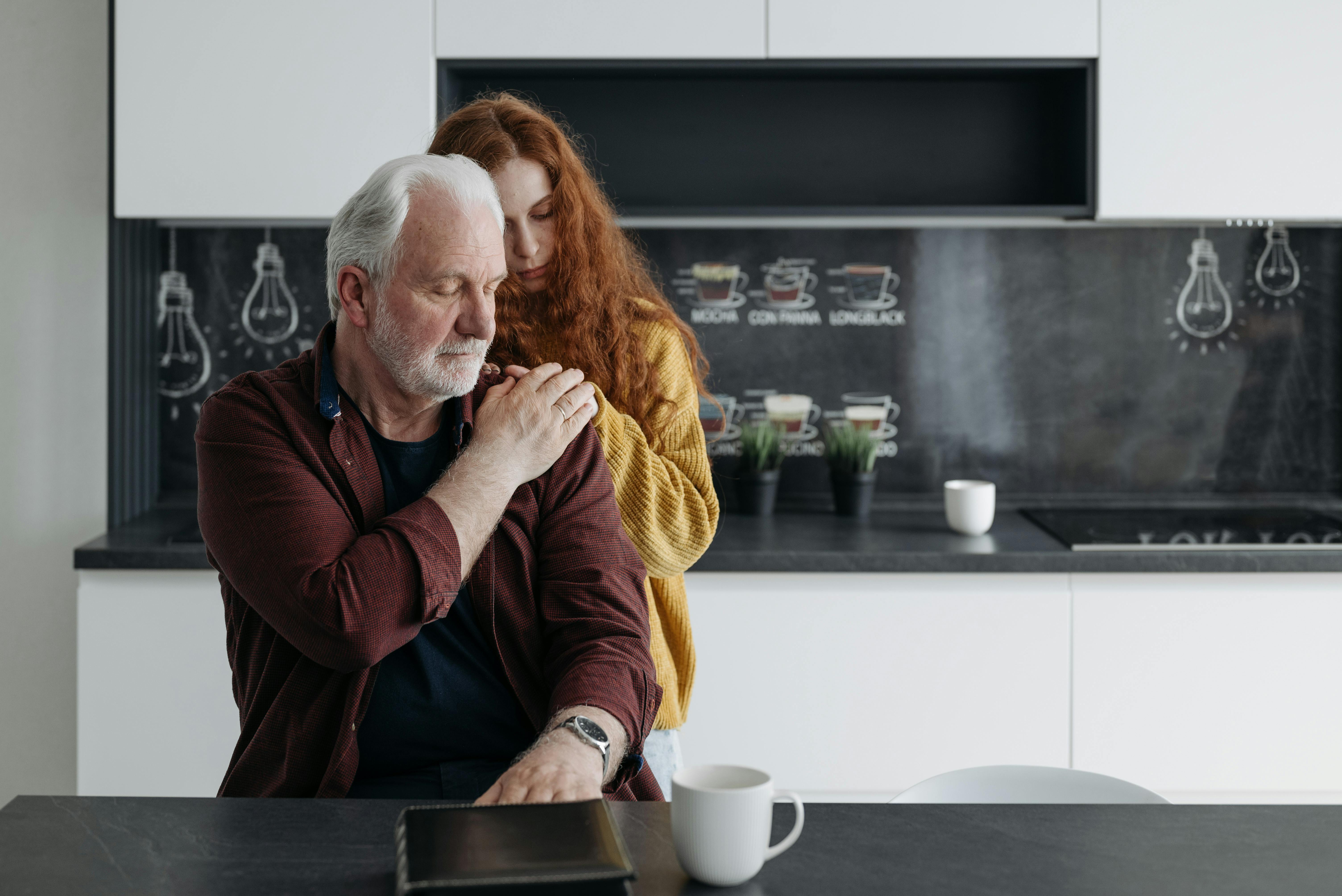 A sad young girl embracing an older man | Source: Pexels