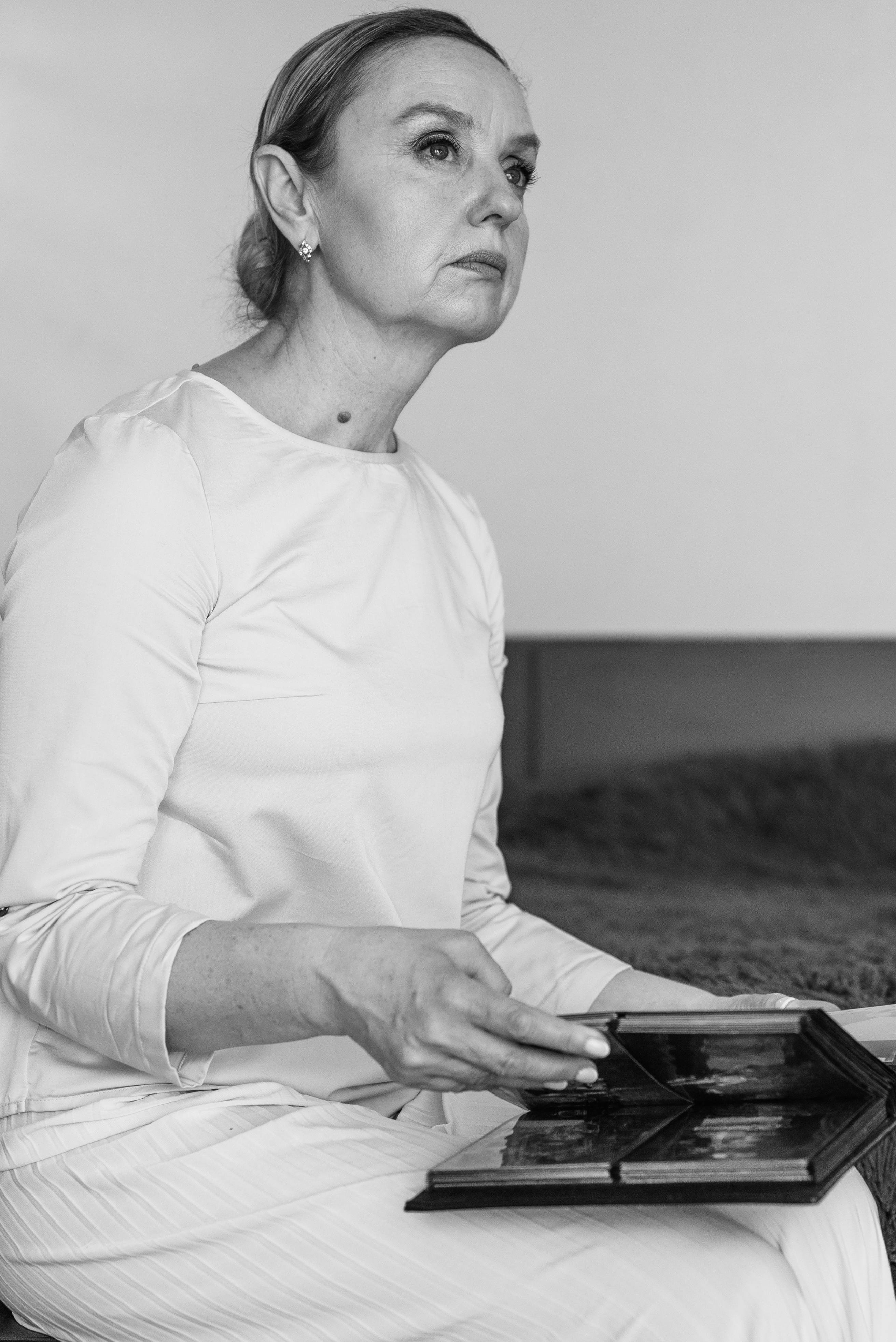 A neutral-looking woman holding a photo album | Source: Pexels