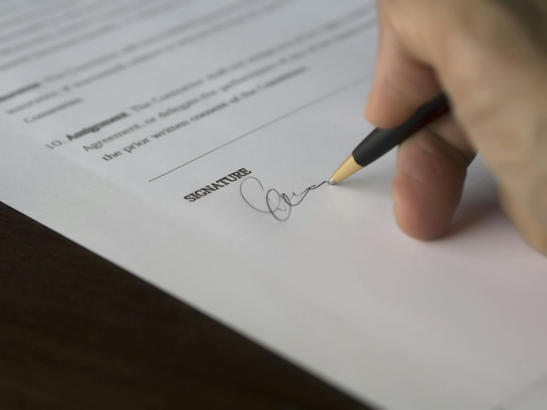 A person signing a document | Source: Pexels