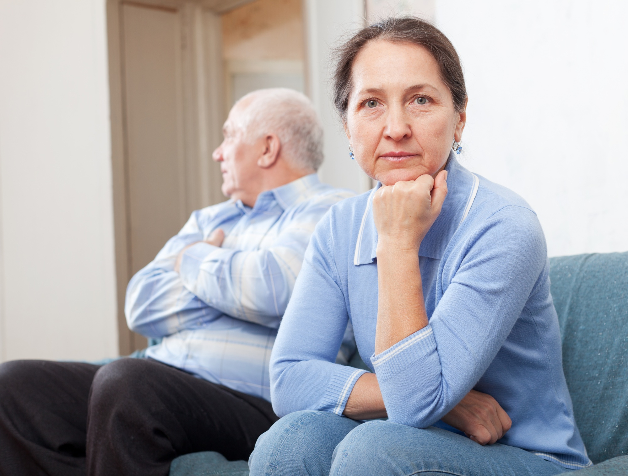 A serious couple sitting on a couch | Source: Freepik